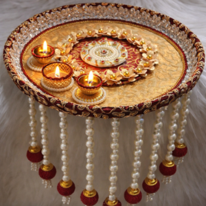 Handmade red and gold bridal pooja thali with 9 pearl tassel hangings and decorative diya holders.